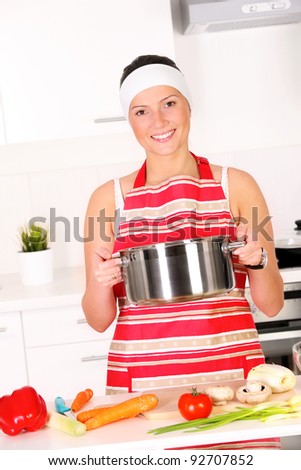A portrait of a young beautiful wife working in a modern kitchen