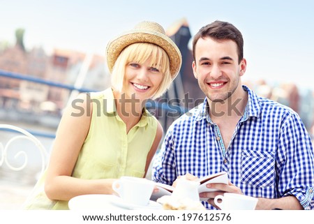 A picture of a young couple reading a guide in a restaurant
