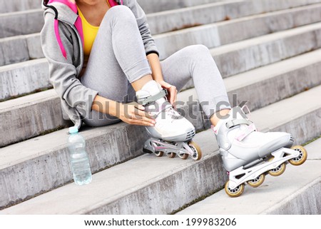 A picture of a woman butting on roller-blades on concrete stairs
