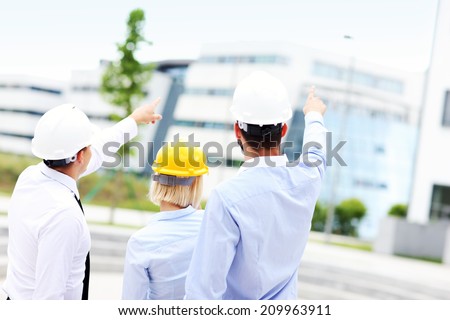 A picture of a group of architects on site pointing at modern buildings