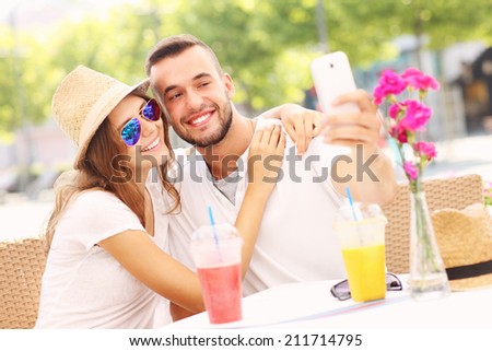 A picture of a happy couple taking selfie in a cafe