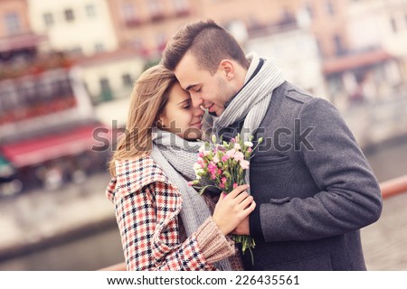 A picture of a romantic couple with flowers on an autumn walk