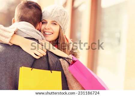 A picture of a beautiful woman hugging a man while shopping
