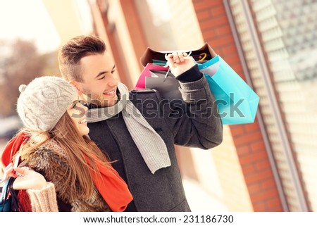 A picture of a beautiful couple shopping together in the city
