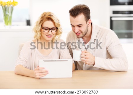 A picture of a happy couple using tablet at home