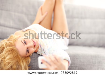 A picture of a sexy woman lying on sofa and taking selfie