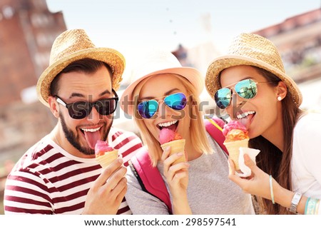 A picture of a group of friends eating ice-cream in front of big wheel in Gdansk
