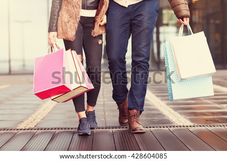 Midsection of couple with shopping bags in city