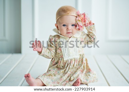 small cute baby girl with a adorable flower in fer head and in beautiful dress
