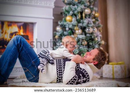 cute funny baby girl and her father in christmas interior