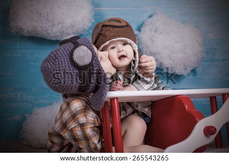 adorable babies brother and sister kissing sitting in toy airplane on wooden background true emotions and feelings