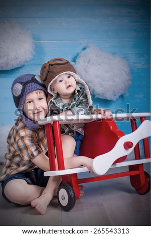 adorable babies brother and sister hugging each other in toy airplane on wooden background true emotions and feelings
