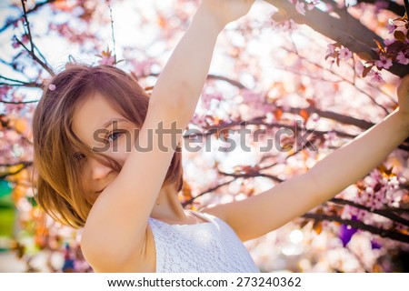 smiling emotional cute adorable baby girl portrait in blossom pink flowers tree art beauty