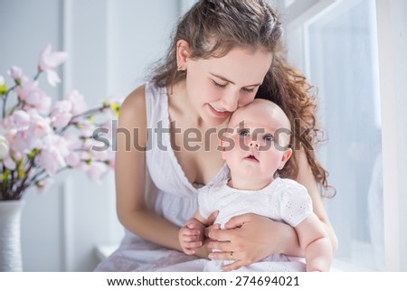 family portrait mother and daughter kissing and hugging with flowers background