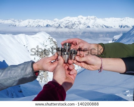 Celebration in mountains.  Shots of spirits at the top of mountain summit during ski tour in the Alps.