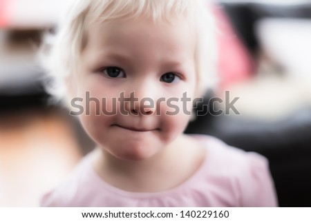 3 year old blonde girl in high key with various expressions.