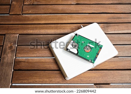 Image of book and computer hard disk on the wood table