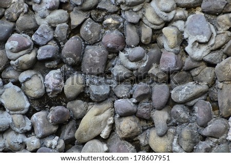 Wall made up of small river stones connected to each other with concrete