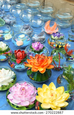 Pretty, bright and beautiful colors of plastic flowers in water filled flasks