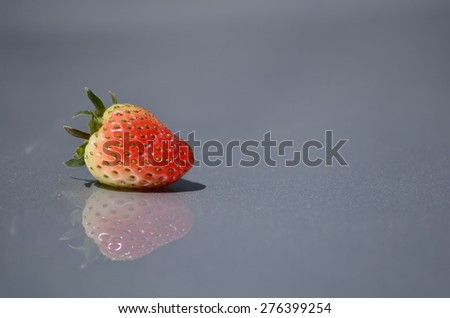 Fresh Juicy strawberry and its reflection on metal sheet