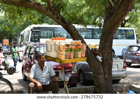 Editorial: New Delhi, India, A local vendor selling street food in New Delhi, vendor is sitting under tree to beat hot summer