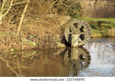 Old wheel driven by water, a corner of the lake Alserio in the province of Como,  region of Lombardy, Italy in March 2014