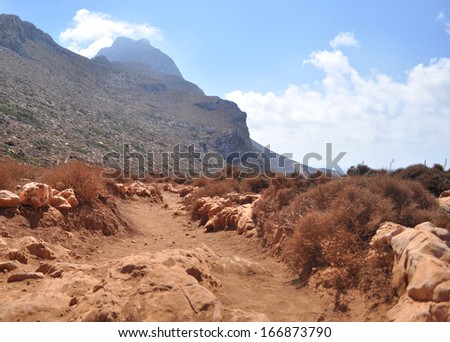 Red dusty road in the mountains on the Greek island. Mediterranean sea, the island of Crete. Greece.