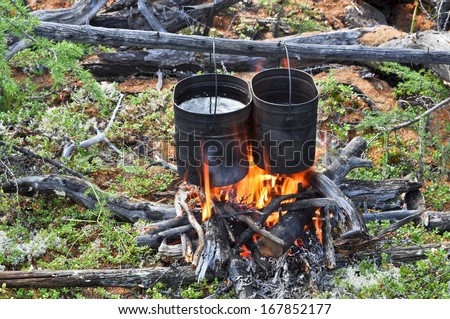 Cooking on camp fire. Russia, Eastern Yakutia, a ridge of Suntar-khayata, river Suntar.