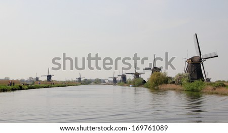 Dutch landscape with windmills. Gloomy panorama of gray water channel and windmills in Holland.