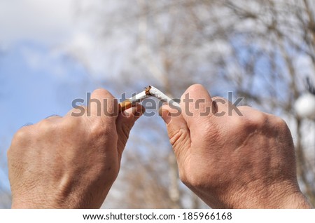 Spring is a good time to stop Smoking. Broken cigarette in his hand, against the background of the spring sky.