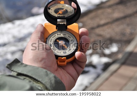 Man holds in his hand the magnetic compass, not to get lost away from home.