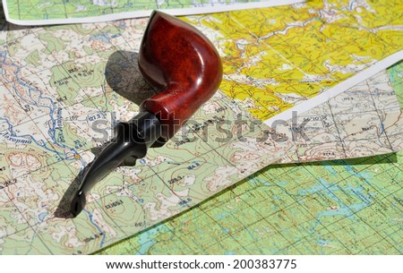 Map and Smoking pipe. The indispensable accessories for travel and adventure.