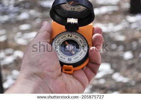 Man holds in his hand the magnetic compass, not to get lost away from home.