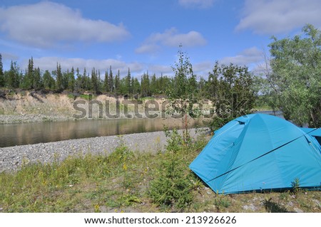 Camping tent by the river. Camping tent is located on the North river. The Polar Urals, Russia.