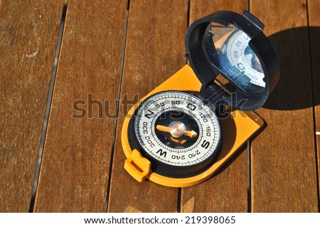 The compass on the boards. Open the magnetic compass lies on the dark wooden boards