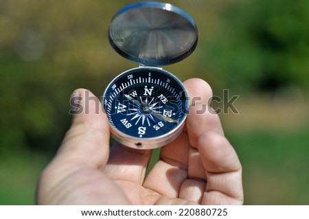 Compass in hand. Open the magnetic compass holds the left hand men.
