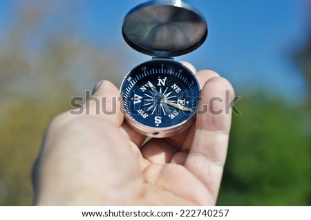 Compass in hand. Open the magnetic compass holds the left hand men.