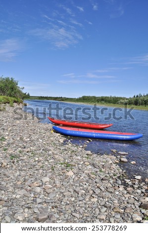 Two inflatable canoes on the shore of the North river. Polar Ural, Komi Republic, Russia.