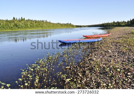 Taiga river Paga, Russia, the Polar Urals.  Inflatable kayaks on the shore of the river.