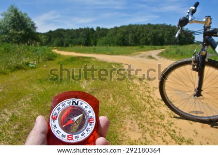 With a compass and a Bicycle front fork. Orientation during a bike ride in rural areas.