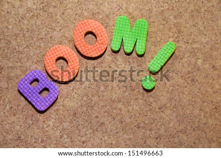 the word boom in foam colored letters on cork