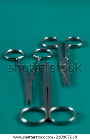 Medical scissors on green