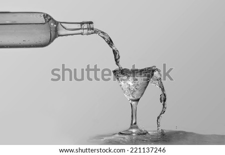 Black and white of wine bottle and martini glass overflowing