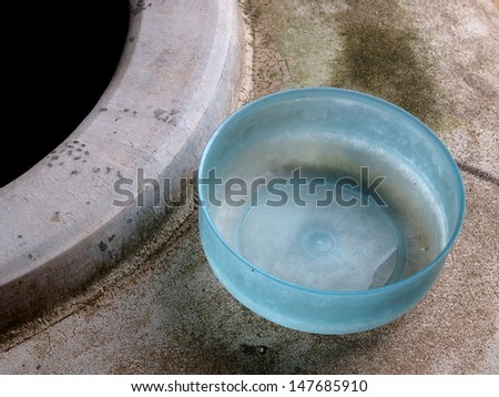 blue water bowl on a large concrete water tank