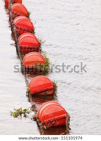 red floating buoy with rope hanging swimming on water at a dam signate no entry zone for fisherman\'s boat