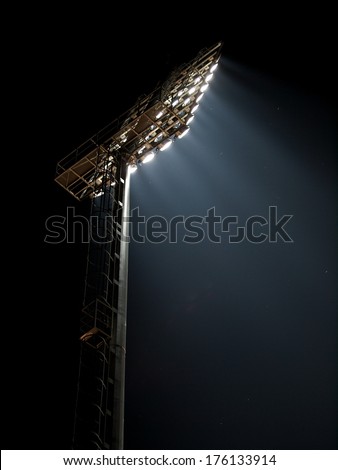 powerful bright large tall outdoor stadium spotlights on working with dark sky background