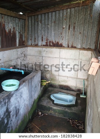 old dirty retro style toilet combine with bathroom in a country house in typical agricultural country life in Thailand.