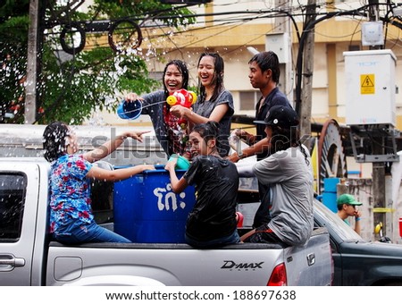 Chachoengsao Province 13 April 2014: Thai people and children wearing colorful clothes celebrate Songkran festival splashing water with bowls and water spray guns on the street in cities of Thailand