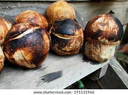 burning peeled coconut already roasted, cleaned and cool down as last step of making roasted coconut, exotic but typical refreshment drink for warm summer time in Thailand.