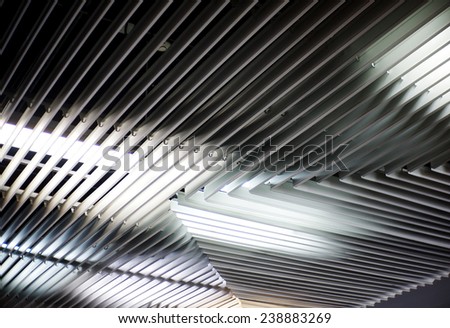 light metal aluminum grid frame louver ceiling design indoor in a corridor for better air flowing for tropical modern architecture with light reflections from underneath